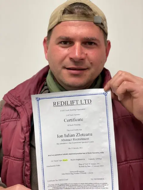 Trained worker holding his lift truck operator certificate