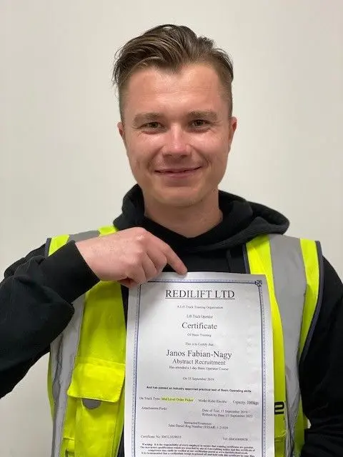 Warehouse worker displaying his completed lift truck training certificate